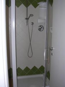 a shower in a bathroom with green and white tiles at Casa di Lory in Sirolo