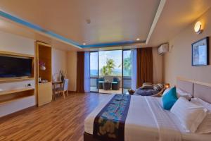 a hotel room with a bed and a television at Season Paradise in Thulusdhoo