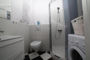 ワルシャワにあるASKI Hoża Apartmentのバスルーム(トイレ、シャワー、洗濯機付)