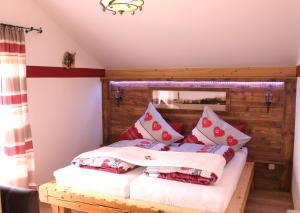 Schlafzimmer mit einem Bett mit roten und weißen Kissen in der Unterkunft Reiherhof in Brünning