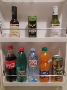 a refrigerator filled with bottles of soda and drinks at V&J apartments in Podgorica +20 photos