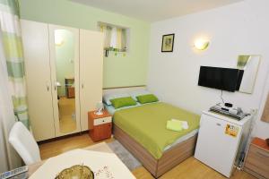 a small bedroom with a bed and a television at Apartment Boris in Zadar