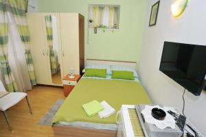 a small room with a bed and a television at Apartment Boris in Zadar