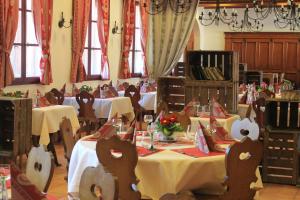 une salle à manger avec deux tables et des nappes blanches dans l'établissement Les Loges de l'Ecomusée D'Alsace, à Ungersheim