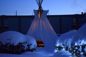 ein Kleid ist mit Schnee bedeckt in einem Hof in der Unterkunft Ramada by Wyndham Timmins in Timmins