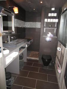 a bathroom with a black toilet and a sink at Chambre Proche Dune du Pyla in Pyla-sur-Mer