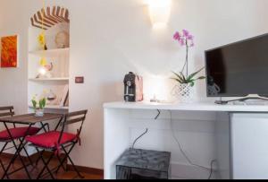 Una Volta in Brera في ميلانو: غرفة بها مكتب مع جهاز كمبيوتر وطاولة مع كراسي