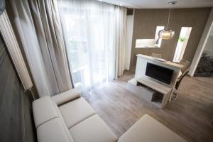ブダペストにあるAll Seasons Apartmentのリビングルーム(テレビ、白いソファ付)