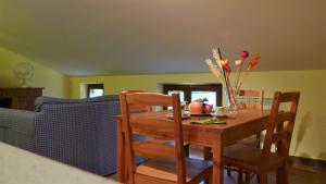 einen Holztisch mit Stühlen und eine Schale mit Obst darauf in der Unterkunft Appartamenti Albarosa by Holiday World in Sigillo