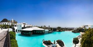 a large pool with blue water in a resort at Hotel LIVVO Volcán Lanzarote in Playa Blanca