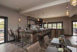 a bar in a restaurant with chairs and tables at Fletcher Boutique Hotel Duinoord in Wassenaar