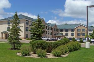 un gran edificio con coches estacionados en un estacionamiento en Extended Stay America Suites - Minneapolis - Woodbury, en Woodbury