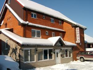 a large brick building with snow on it at Hotel Čile in Kolašin