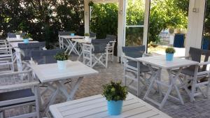a row of tables and chairs with potted plants on them at Akrogiali in Skala +37 photos