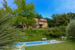 a house with a swimming pool in front of a yard at Holiday Home Soratte in Civitella San Paolo