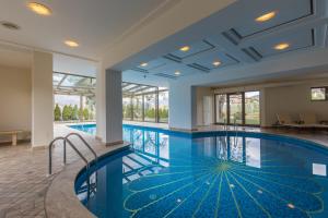 uma grande piscina com água azul num edifício em Hotel Girlanerhof em Appiano sulla Strada del Vino