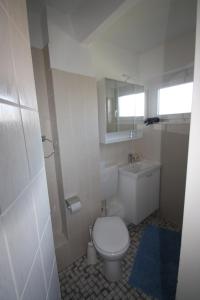 a bathroom with a white toilet and a sink at Armarova Ihre Ferienpension in Cuxhaven +63 photos