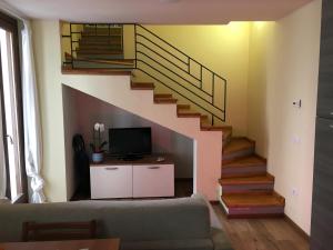 a living room with a staircase and a television at La Maison di La Thuile in La Thuile
