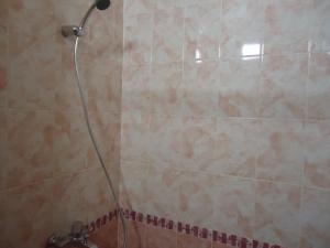 y baño con ducha con cabezal de ducha. en Tumar en Bishkek