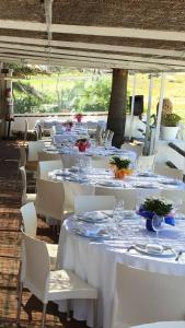 un grupo de mesas y sillas blancas con platos y vasos en Hostal Rios en Bolonia