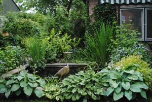 a garden with plants and a bird in the middle at Elegance Hamont in Hamont