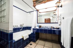 a blue and white bathroom with a tub and a sink at Hotel La Mansion del Sol in Guadalajara