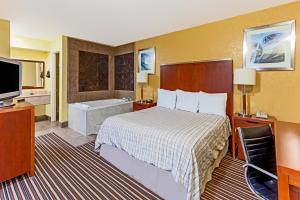 una camera d'albergo con un letto e una vasca da bagno di Lodge at Mill Creek Pigeon Forge a Pigeon Forge