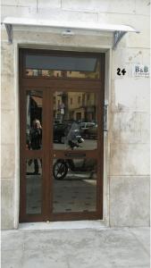 una puerta a un edificio con un reflejo en él en B&B Le Coppole, en Palermo