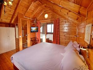 a bedroom with a large bed in a wooden cabin at Nofesh Ne'eman in Amirim