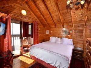 a bedroom with a bed in a wooden cabin at Nofesh Ne'eman in Amirim