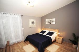 a bedroom with a bed with black sheets and a window at Top Center Zadar Studio Apartments in Zadar