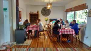 un grupo de personas sentadas en mesas en un restaurante en Hostal Petit Verdot, en Santa Cruz