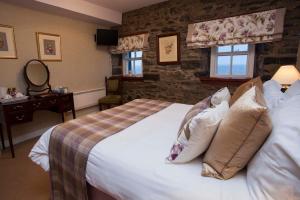 a bedroom with a large bed with pillows at Port Charlotte Hotel in Port Charlotte