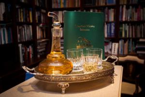 a tray with a bottle of whiskey and glasses on a table at Port Charlotte Hotel in Port Charlotte