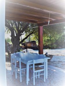 uma mesa azul e cadeiras sob um pavilhão em La Ginestra em Orosei