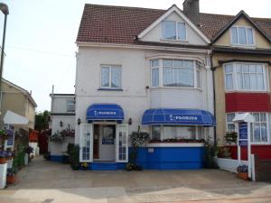 a house with blue awnings on the front of it at The Florida Guest House in Paignton