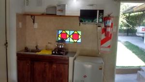 a kitchen with a sink and a refrigerator and a window at Cabañas Molinos de Vientos in Potrero de los Funes