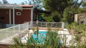 a swimming pool with a white fence next to a house at Cabañas Molinos de Vientos in Potrero de los Funes