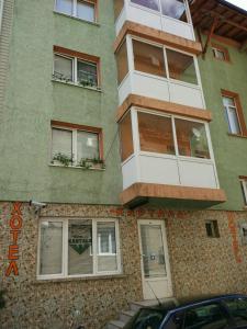 un bâtiment avec des fenêtres et un panneau sur celui-ci dans l'établissement Family Hotel Kartala, à Blagoevgrad