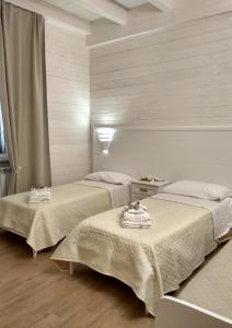 Habitación con 2 camas y toallas. en Le Camelie en Ginosa Marina