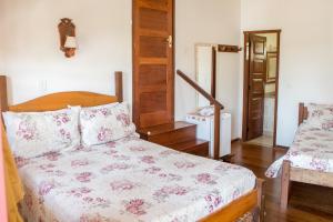 a bedroom with a bed and a dresser at Pouso Lar Doce Lar in Tiradentes