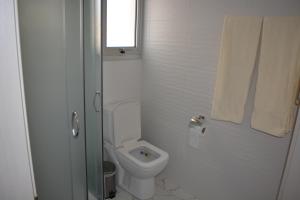 a white bathroom with a toilet and a window at P L PANAGIOTIS Apartment in Larnaka +27 photos