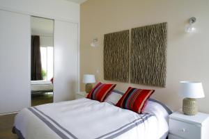 - une chambre avec un lit doté d'oreillers rouges et d'un miroir dans l'établissement Casa Marcelino, à Tavira