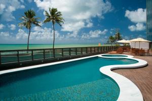 uma piscina com vista para a praia em Ritz Suites Lifestyle em Maceió