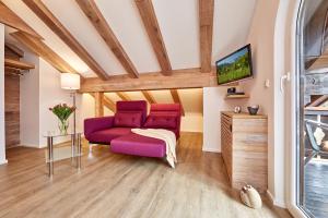 uma sala de estar com um sofá roxo e uma televisão em Ferienwohnung Wittmann em Garmisch-Partenkirchen