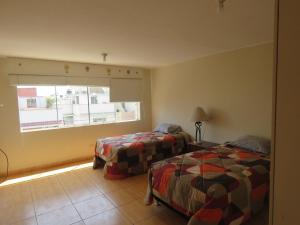 um quarto de hotel com duas camas e uma janela em Casa particular de Jorge Edinson em Lima
