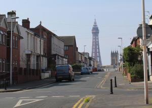 a street with cars driving down a street with a tower at Blackpoolholidaylets Charles Street in Blackpool