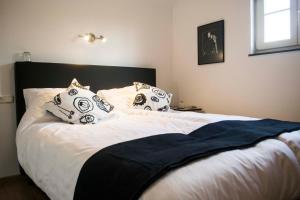 a bedroom with a large bed with white sheets and pillows at Huize Mesch in Eijsden