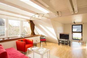 sala de estar con sofá rojo y TV en Ferienwohnung Gilg en Cuxhaven