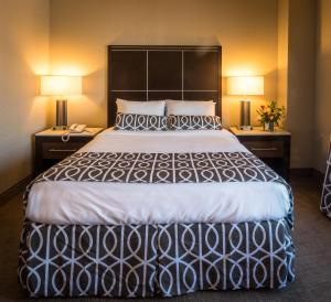 a large bed in a hotel room with two lamps at Olyver Hotel in Los Angeles